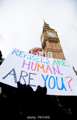 La piazza del Parlamento, Westminster, London, Regno Unito 5 Marzo 2016 - Protester detiene una targhetta passando dal Big Ben. Centinaia di manifestanti fase una dimostrazione organizzata da Londra2Calais gruppo contro i recenti avvenimenti in campi per rifugiati a Calais. I manifestanti hanno bloccato il Westminster Bridge per un tenendo il traffico in entrambe le direzioni. Credito: Dinendra Haria/Alamy Live News Foto Stock