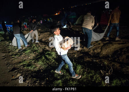 Idomeni, Grecia. 05 Mar, 2015. I bambini rifugiati trasportare la legna attraverso il campo profughi al confine Greek-Macedonian in Idomeni, Grecia, 05 marzo 2015. Solo pochi rifugiati dalla Siria e Iraq vengono lasciate oltre confine in Macedonia ogni giorno. Foto: KAY NIETFELD/dpa/Alamy Live News Foto Stock