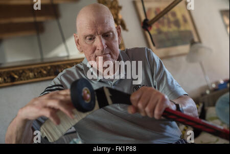 Bad Toelz, Germania. 02Feb, 2016. Ex giocatore professionale del hockey di ghiaccio Lorenz nastri Funk il suo ice hockey stick nella sua casa di Greiling vicino a Bad Toelz, Germania, 02 febbraio 2016. Il funk è stato membro del West team nazionale tedesco che ha vinto la medaglia di bronzo del 1976 Olimpiadi invernali di Innsbruck, in Austria. Sei mesi fa, Lenzo è stato diagnosticato un cancro. Foto: Matthias esitano di fronte/dpa/Alamy Live News Foto Stock