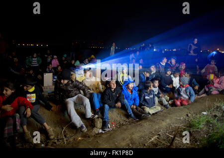 Idomeni, Grecia. 05 Mar, 2015. I bambini rifugiati guardare un film al di fuori del campo profughi al confine Greek-Macedonian in Idomeni, Grecia, 05 marzo 2015. Solo pochi rifugiati dalla Siria e Iraq vengono lasciate oltre confine in Macedonia ogni giorno. Foto: KAY NIETFELD/dpa/Alamy Live News Foto Stock