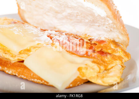 La colazione panino con pancetta e fritti uova strapazzate. Close Up di Toast a caldo con formaggio e prosciutto bollito. Toast fritti in inglese Foto Stock