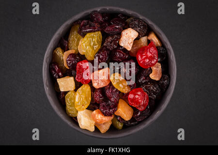 Mix varietà di frutta secca in coppa sopra il nero scuro dello sfondo di pietra Foto Stock