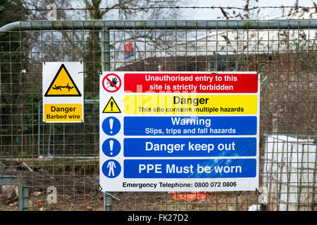 La salute e la sicurezza e waring segni sul perimetro della scatola sito in costruzione a Bicester, Oxfordshire, Inghilterra Foto Stock