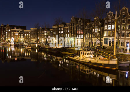 Una vista lungo il canale Waalseilandgracht ad Amsterdam di notte. Edificio, barche e riflessioni può essere visto. Vi è spazio per Foto Stock