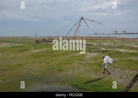 Kochi, India - 1 Novembre 2015 - uomo senza tetto la raccolta di rifiuti sulla spiaggia di Kochi, India Foto Stock