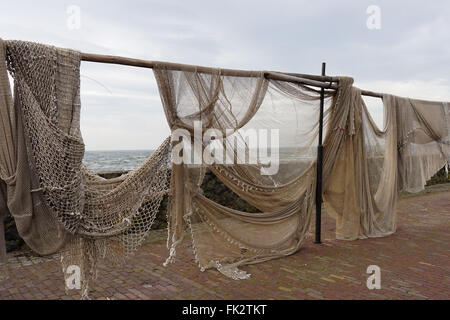 Commerciale di reti da pesca appesa ad asciugare nello storico villaggio di pescatori di Urk nei Paesi Bassi Foto Stock