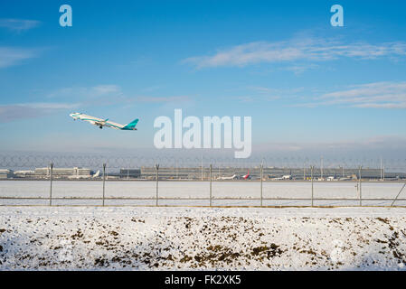 Embraer ERJ 195 aereo decolla all'aeroporto di Monaco di Baviera della pista sud in un assolato pomeriggio invernale - tutti i marchi e i loghi rimosso Foto Stock