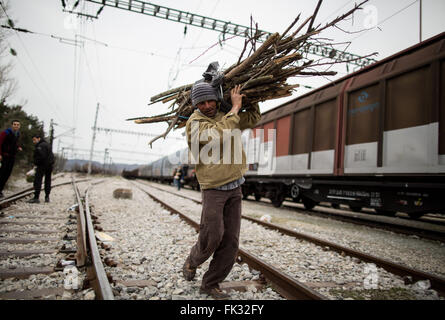 Idomeni, Grecia. 06 Mar, 2016. Un uomo porta legna da ardere al campo profughi al confine Greek-Macedonian vicino Idomeni, Grecia, 06 marzo 2016. Solo pochi rifugiati dalla Siria e Iraq sono ammessi a croce in Macedonia ogni giorno. Foto: KAY NIETFELD/dpa/Alamy Live News Foto Stock