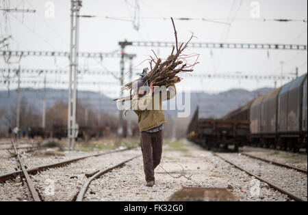 Idomeni, Grecia. 06 Mar, 2016. Un uomo porta legna da ardere al campo profughi al confine Greek-Macedonian vicino Idomeni, Grecia, 06 marzo 2016. Solo pochi rifugiati dalla Siria e Iraq sono ammessi a croce in Macedonia ogni giorno. Foto: KAY NIETFELD/dpa/Alamy Live News Foto Stock