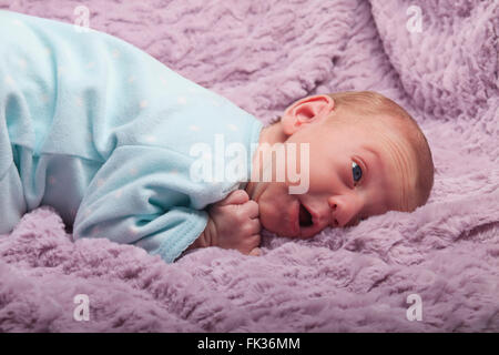 Adorabili redhead neonato guarda con espressioni di sorpresa Foto Stock