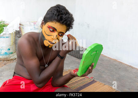 Giovane uomo a mettere su il trucco per Therukoothu spettacolo teatrale, Purisai Foto Stock