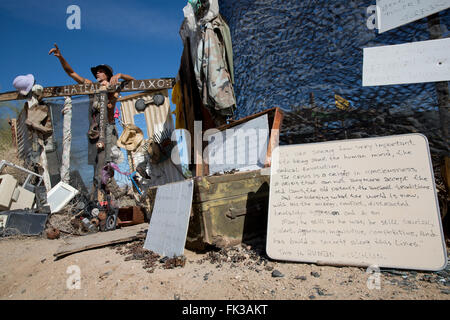 Karibe, un residente della città di Soletta, sorge in corrispondenza del cancello al suo accampamento, Niland, California USA Foto Stock