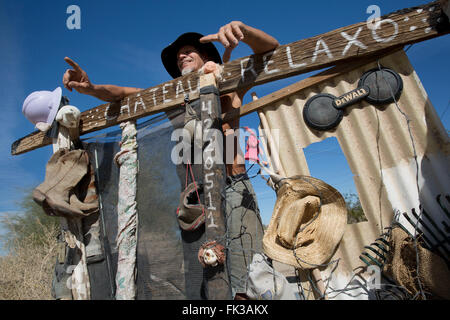 Karibe, un residente della città di Soletta, sorge in corrispondenza del cancello al suo accampamento, Niland, California USA Foto Stock