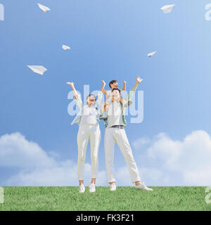 Famiglia giapponese volare aerei di carta in un parco della città Foto Stock