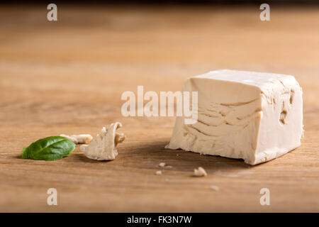 Il lievito sbriciolato cubo su una tavola di legno Foto Stock