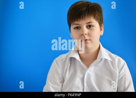 Ritratto di ragazzo adolescente su sfondo blu Foto Stock
