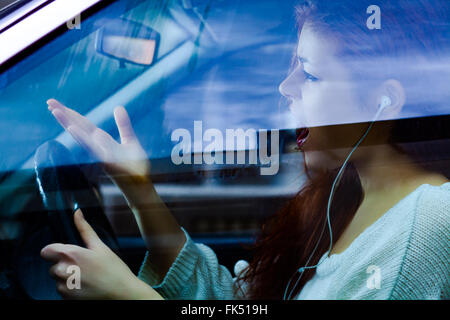 Donna arrabbiato grida mentre si è alla guida di un veicolo Foto Stock