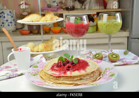 Frittelle di morbido naturale con gelatina di lamponi con appena fatto lampone e kiwi frullati servita per prima colazione Foto Stock