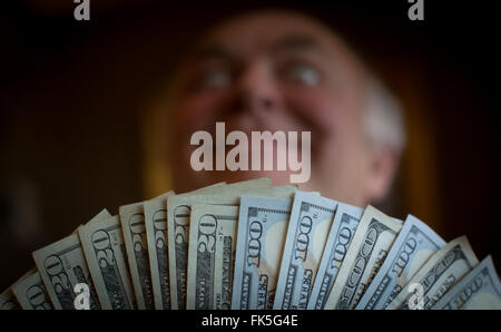 L'uomo pone con noi banconote Foto Stock