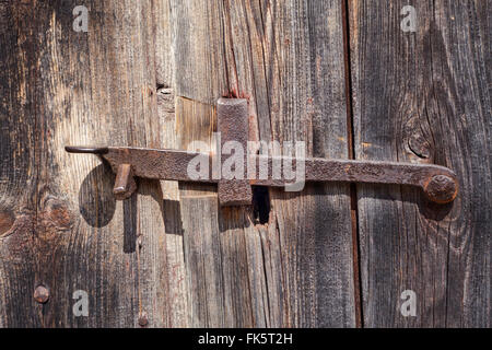 Il vecchio metallo arrugginito fermo sul legno stagionato di un vecchio fienile Foto Stock