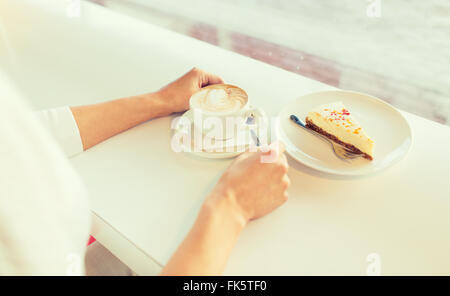 Close up della donna le mani con torta e caffè Foto Stock