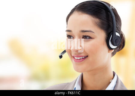 Immagine composita di operatore felice in posa con una cuffia Foto Stock