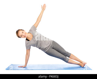 Donna fare yoga nella posizione del cobra pone sul tappeto Foto Stock