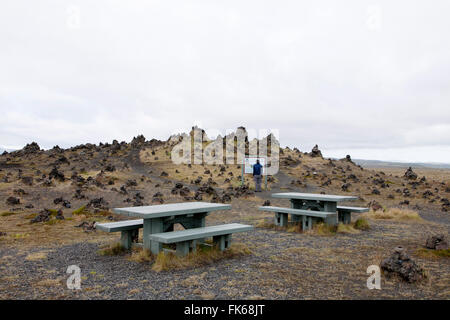 Islanda, panchine in un parcheggio con un turista Foto Stock