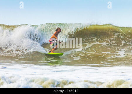 Uomo di mezza età surf a questo hip resort vicino a mal Pais, estremo sud della penisola di Nicoya, Santa Teresa, Puntarenas, Costa Rica Foto Stock