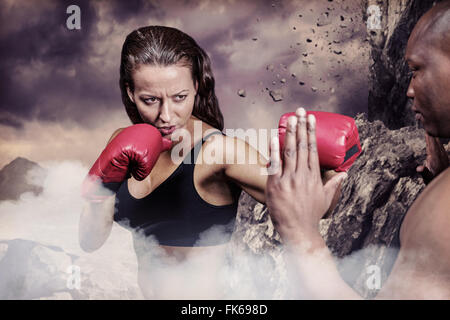 Immagine composita del boxer femmina praticando con trainer Foto Stock