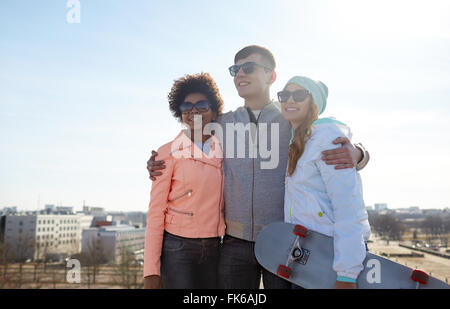 Happy amici adolescenti in sfumature parlando su strada Foto Stock