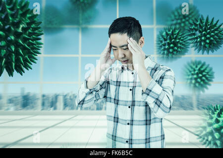 Immagine composita di uomo asiatico ottenendo un mal di testa Foto Stock
