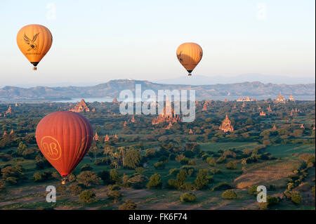 I palloni ad aria calda volare sopra i templi in terracotta di Bagan con il fiume Irrawaddy in distanza, Bagan, Divisione Mandalay Foto Stock