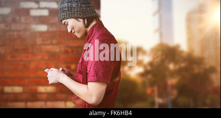 Immagine composita di sorridere hipster imprenditore usando il telefono Foto Stock