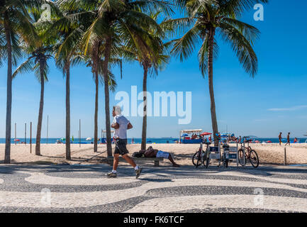 Le persone corrono e rilassarsi sul marciapiede di Copacabana a Rio de Janeiro. Nuovo masterizzatore di età Foto Stock