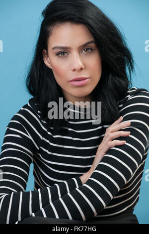 Modello femminile con i capelli neri, indossando compongono in studio. Foto Stock