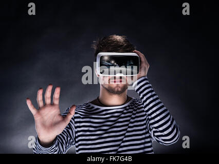 Uomo che indossa la realtà virtuale gli occhiali. Studio shot, backgrou nero Foto Stock