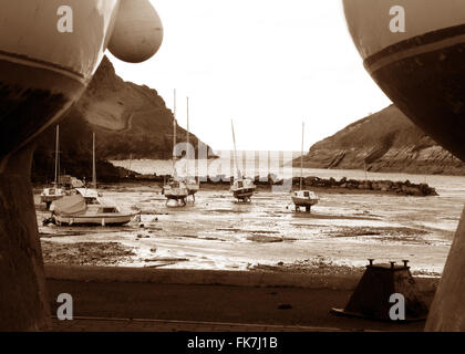 Classe Watermouth Cove nelle vicinanze del Ilfracombe Devon marea fuori vista dall'Harbourside attraverso gli scafi di imbarcazioni Moody foto Foto Stock