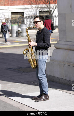 Giovane uomo suonare il sassofono sotto il Washington Square Park Arch Greenwich Village di New York City Foto Stock