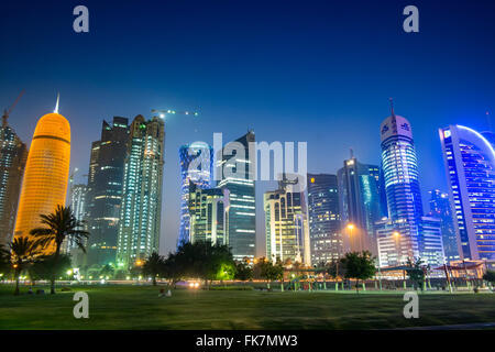 Vista notturna della skyline lungo la Corniche verso moderne torri di uffici a Doha in Qatar Foto Stock