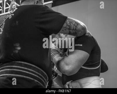 Fotografia documentaria dalla potenza di un evento di sollevamento dotata di uomini deadlifting e panca premendo e vivendo il trionfo e lo stress Foto Stock