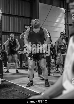 Fotografia documentaria dalla potenza di un evento di sollevamento dotata di uomini deadlifting e panca premendo e vivendo il trionfo e lo stress Foto Stock