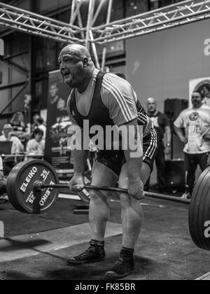 Fotografia documentaria dalla potenza di un evento di sollevamento dotata di uomini deadlifting e panca premendo e vivendo il trionfo e lo stress Foto Stock