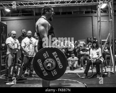 Fotografia documentaria dalla potenza di un evento di sollevamento dotata di uomini deadlifting e panca premendo e vivendo il trionfo e lo stress Foto Stock