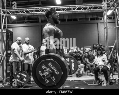 Fotografia documentaria dalla potenza di un evento di sollevamento dotata di uomini deadlifting e panca premendo e vivendo il trionfo e lo stress Foto Stock