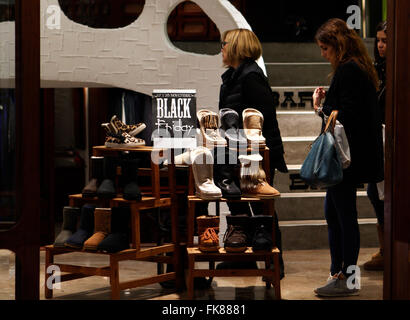 Womens cercando di scarpe in un negozio durante il Venerdì nero. In una giornata aperta e molto affollato. Foto Stock