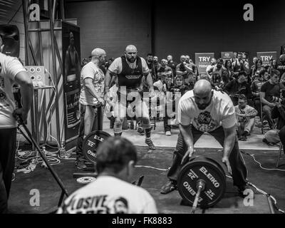 Fotografia documentaria dalla potenza di un evento di sollevamento dotata di uomini deadlifting e panca premendo e vivendo il trionfo e lo stress Foto Stock