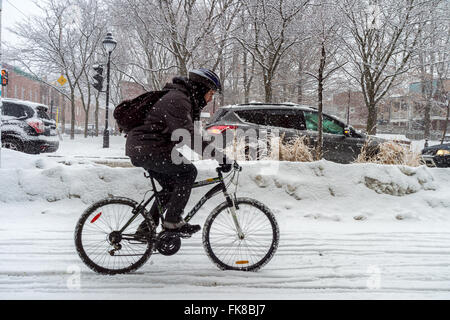 Montreal, CA, 7 marzo 2016. Uomo in Bicicletta Equitazione su Rachel Street durante la tempesta di neve Foto Stock