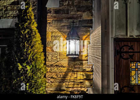 Vecchia lampada su un muro di pietra Foto Stock