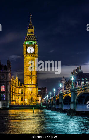 La bellissima Elizabeth Tower con le campane del Big Ben in alto e il Parlamento nei pressi di un ponte sopra il fiume Tamigi a Londra di notte. Foto Stock